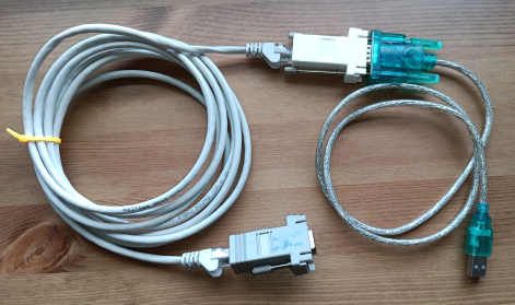 Photo of usb-to-serial adapter, 1 straight RJ45-to-DB9, 1 crossed RJ45-to-DB9 and a coiled up patch cable